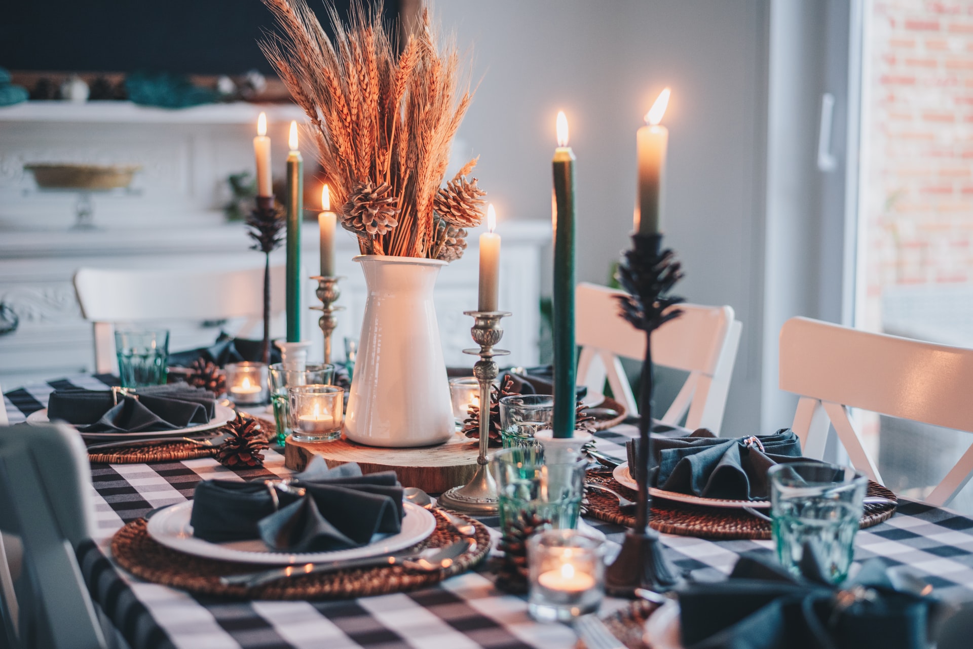 Dining room table set up for a holiday dinner with candles and flowers
